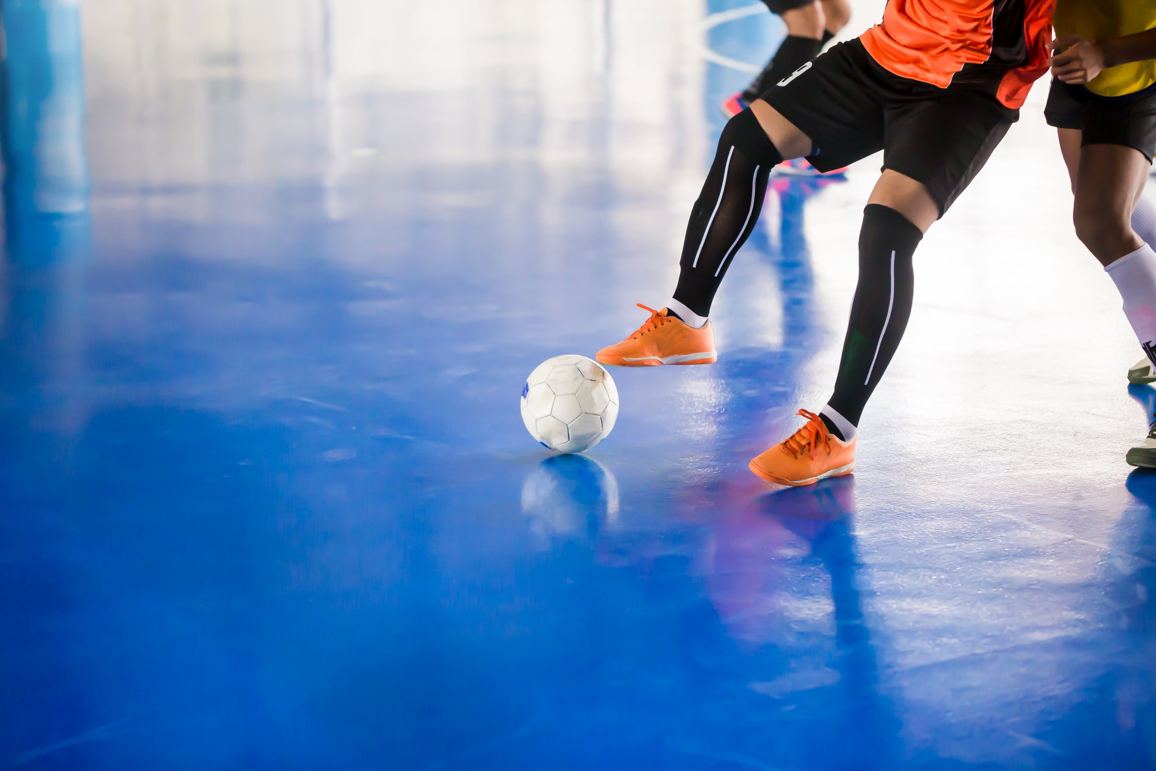 Indoor soccer sports hall. Football futsal player, ball, futsal floor. Sports background.